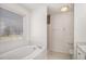 Well-lit bathroom with soaking tub and window providing natural light at 142 Parkside Dr, Stockbridge, GA 30281