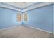 Comfortable bedroom with neutral carpeting, two windows and a tray ceiling at 142 Parkside Dr, Stockbridge, GA 30281