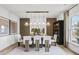 Elegant dining room with modern lighting, wood accent wall, and seating for six, perfect for entertaining at 221 Kindness Cir, Mcdonough, GA 30252