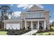 Charming two-story brick home with a covered front porch, manicured landscaping, and a two car garage at 221 Kindness Cir, Mcdonough, GA 30252