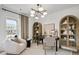 Bright and airy home office with stylish decor, including a plush chair and wood shelving, for a comfortable work space at 221 Kindness Cir, Mcdonough, GA 30252