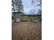 The overgrown backyard shows the home's exterior and surrounding greenery in need of maintenance at 2836 Oldknow Dr, Atlanta, GA 30318