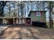 View of a two-story home with brick and wood facade, covered parking, and a yard at 2836 Oldknow Dr, Atlanta, GA 30318