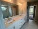 Elegant main bathroom featuring double sinks, a large mirror, a walk-in shower, and modern fixtures at 320 Willow Cv, Canton, GA 30114
