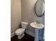 Classic powder room featuring a pedestal sink, toilet, oval mirror, and hardwood floors at 320 Willow Cv, Canton, GA 30114