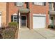 Charming townhouse entrance with a black front door, single car garage, and neatly trimmed shrubs at 3815 Pleasant Oaks Dr, Lawrenceville, GA 30044