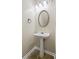 Stylish powder room featuring pedestal sink and decorative mirror at 3815 Pleasant Oaks Dr, Lawrenceville, GA 30044