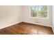 Empty bedroom featuring hardwood floors and a window with views of the outdoors at 422 Derbyshire Dr, Stone Mountain, GA 30088