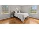 Bright bedroom with two windows, hardwood floors, and a comfortable bed at 422 Derbyshire Dr, Stone Mountain, GA 30088