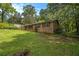 Landscaped backyard featuring green grass, mature trees, and a brick home with a covered porch, offering a serene outdoor space at 422 Derbyshire Dr, Stone Mountain, GA 30088