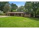 Charming brick home with an attached covered carport and a well-maintained front lawn surrounded by mature trees at 422 Derbyshire Dr, Stone Mountain, GA 30088