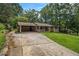 A well maintained home featuring a brick facade, a covered carport, a long driveway, and a green lawn at 422 Derbyshire Dr, Stone Mountain, GA 30088