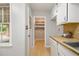 Kitchen area with a view to a pantry through a doorway, includes a window and a white dishwasher appliance at 422 Derbyshire Dr, Stone Mountain, GA 30088