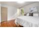 Main bedroom with a king bed, hardwood floors, natural light from window, and view to bathroom at 422 Derbyshire Dr, Stone Mountain, GA 30088