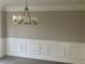 Dining room featuring modern chandelier and decorative wainscoting at 6023 Kingston Wood Way, Lithonia, GA 30038
