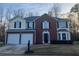 Two-story home featuring brick and siding, a two-car garage, and manicured landscaping at 6023 Kingston Wood Way, Lithonia, GA 30038