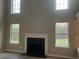 Living room with fireplace and large windows, providing ample natural light at 6023 Kingston Wood Way, Lithonia, GA 30038