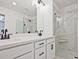 Bathroom featuring dual sinks with dark hardware, quartz countertops, and a view of the walk-in shower at 4655 Larkfield Way, Powder Springs, GA 30127