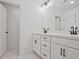 Modern bathroom featuring dual sinks, white cabinetry, dark fixtures, and a large mirror at 4655 Larkfield Way, Powder Springs, GA 30127