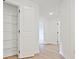 Bright hallway featuring a storage closet with white wood shelving and beautiful light wood floors at 4655 Larkfield Way, Powder Springs, GA 30127