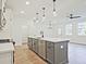 Bright open-concept kitchen featuring gray island, modern faucet, and stainless steel dishwasher at 4655 Larkfield Way, Powder Springs, GA 30127