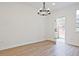 Bright living room with wood-look floors, a modern chandelier, and backyard access at 4655 Larkfield Way, Powder Springs, GA 30127