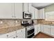 Stylish kitchen with white cabinetry, granite countertops, and stainless steel appliances at 5310 Corinth Ct, Cumming, GA 30040