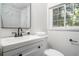 Updated bathroom with white marbled shower, vanity, and a window for natural light at 1712 Evans Sw Dr, Atlanta, GA 30310