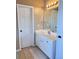 Well-lit bathroom with white cabinetry, a framed mirror, and tiled floors at 3345 Stoneleigh Run Dr, Buford, GA 30519