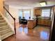 Open kitchen with wood cabinets, an island, hardwood floors, and a view of the dining area at 3345 Stoneleigh Run Dr, Buford, GA 30519