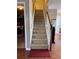 Carpeted stairs feature a wooden railing and white bannister leading up to the upper floor of the house at 3345 Stoneleigh Run Dr, Buford, GA 30519