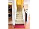 Carpeted stairway with stained wood banister and railing, connecting to a laundry area at 3345 Stoneleigh Run Dr, Buford, GA 30519