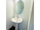 Small, modern powder room featuring a pedestal sink, oval mirror, and white trim at 124 Auburn Run Ln, Auburn, GA 30011