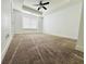 Spacious carpeted bedroom featuring a ceiling fan and natural lighting at 124 Auburn Run Ln, Auburn, GA 30011