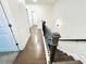 Bright hallway with hardwood flooring, a dark wood banister, and white trim at 124 Auburn Run Ln, Auburn, GA 30011