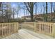 Backyard with wooden deck with railing, a tree, and a privacy fence in the background creating an outdoor living space at 1383 Palmer Sw Pl, Mableton, GA 30126