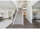 Bright foyer featuring a carpeted staircase, hardwood floors, and views into the living spaces at 1771 Deer Crossing Cir, Jonesboro, GA 30236