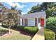 Charming one-story home with stone accents, vibrant orange door, accessible wooden ramp, and manicured landscaping at 361 Oak Harbor Trl, Marietta, GA 30066