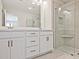 Bathroom featuring double sink vanity with white cabinets, undermount sinks, framed mirrors, and a glass-enclosed shower with tiled walls at 4659 Larkfield Way, Powder Springs, GA 30127