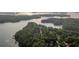 A breathtaking aerial view reveals a sprawling lake surrounded by dense, verdant trees and scattered residential properties at 537 Pearl St, Cumming, GA 30040