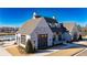 Charming clubhouse with white brick, an outdoor lounge area, a pool, and green space at 537 Pearl St, Cumming, GA 30040