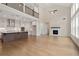 Open-concept kitchen and living room area featuring hardwood floors, large windows, and fireplace at 537 Pearl St, Cumming, GA 30040