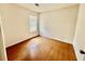 A bright bedroom features wood flooring, neutral paint, and a large window allowing natural light at 5463 Forest East Ln, Stone Mountain, GA 30088