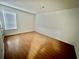 A bright bedroom features wood flooring, neutral paint, and a large window allowing natural light at 5463 Forest East Ln, Stone Mountain, GA 30088