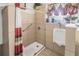 Shower stall with safety bar, surrounded by neutral beige tile and a window above a white retrofitted urinal at 799 Moreland Se Ave, Atlanta, GA 30316