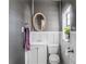 Stylish half bath with a modern sink, toilet, oval mirror, and textured gray wallpaper for a sophisticated design at 799 Moreland Se Ave, Atlanta, GA 30316