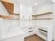 Custom pantry featuring white cabinetry, natural wood shelving, and gold hardware for sophisticated storage at 1600 Spring Arbor Sw Ct, Lilburn, GA 30047