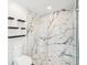 Modern glass shower with a marble design and black fixtures, and black shelving at 1600 Spring Arbor Sw Ct, Lilburn, GA 30047