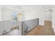 A landing area with hardwood floors, a chandelier, and a window at 1600 Spring Arbor Sw Ct, Lilburn, GA 30047