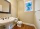 Well-lit half bathroom with a pedestal sink and a view to the outdoors at 6111 Sequoia Ln, Douglasville, GA 30135